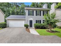 Charming two-story home with gray siding, black shutters, attached garage, and well-manicured lawn at 4800 Countryside E, Stone Mountain, GA 30083