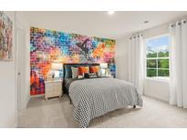 Bright bedroom with an artistic accent wall, soft carpet, and lots of natural light from the large window at 7225 Lacey Lot 147 Dr, Douglasville, GA 30134