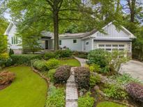 Landscaped front yard with stone walkway leading to a charming light gray home at 2283 Pembrook Ne Pl, Atlanta, GA 30324
