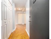 View of hallway with wooden floors, white doors and grey walls leading to the front door at 620 Peachtree Ne St # 1001, Atlanta, GA 30308