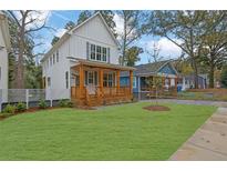 Charming two-story white farmhouse with a welcoming wood porch and a well-manicured green lawn at 830 Gaston Sw St, Atlanta, GA 30310