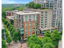 Multi-story condo building with brick facade, balconies, and surrounding trees and city views at 867 Peachtree Ne St # 702, Atlanta, GA 30308