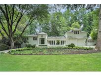 Stunning white brick home with lush landscaping and mature trees create an inviting curb appeal at 3089 Marne Nw Dr, Atlanta, GA 30305