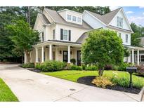 Charming two-story home with a well-manicured lawn, covered porch with stately columns, and a long driveway at 2360 Whispering Nw Dr, Kennesaw, GA 30144