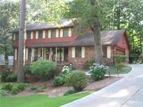 Charming two-story home with brick and wood accents, lush landscaping, and an inviting driveway at 4098 Nancy Creek Ne Way, Brookhaven, GA 30319