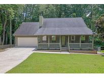 Charming single-story home with a welcoming front porch and a well-maintained front yard at 680 Spirit Falls Way, Johns Creek, GA 30022