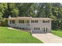 Charming, split-level home featuring a manicured lawn and lovely brick exterior at 3120 Mary Dr, Marietta, GA 30066