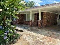 Charming brick home exterior with a covered entryway and landscaped garden at 2711 Fairlane Dr, Atlanta, GA 30340