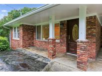 Charming brick home featuring a covered front entry with brick columns at 2711 Fairlane Dr, Atlanta, GA 30340