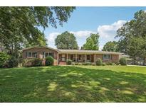 Traditional brick home with manicured lawn and mature trees in a serene setting at 1501 Memory Se Ln, Smyrna, GA 30080