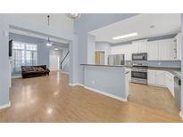 Open-concept living room featuring hardwood floors, stylish decor, and a seamless transition to the modern kitchen at 5013 Centennial Commons Nw Dr, Acworth, GA 30102