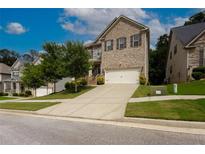 Charming two-story brick home with a manicured lawn and a two-car garage at 565 Lance View Ln, Lawrenceville, GA 30045