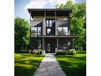 Modern two-story home featuring large windows, a sleek black facade, and lush greenery at 655 Willoughby Ne Way, Atlanta, GA 30312