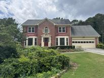 Charming brick two-story home with well-maintained landscaping and attached two-car garage at 25 Darcee Ct, Lawrenceville, GA 30046