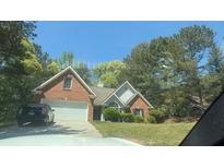 Charming brick home with a well-maintained lawn and a two-car garage at 3510 Hog Mountain Rd, Dacula, GA 30019