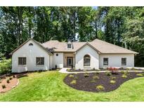 Charming white brick home features manicured landscaping and a lush green lawn at 251 Waller Nw Cir, Marietta, GA 30064