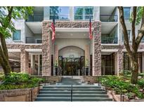 Inviting condominium building entrance with elegant stone facade and manicured landscaping at 275 13Th Ne St # 201, Atlanta, GA 30309