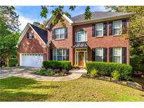 Beautiful two-story brick home with a manicured lawn, tasteful landscaping, and an attached two-car garage at 2540 Ridgehurst Dr, Buford, GA 30518