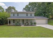 Charming two-story home with a well-manicured lawn, inviting front porch, and attached two-car garage at 5515 Pennybrook Trl, Stone Mountain, GA 30087