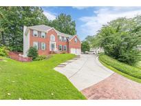 Charming two-story brick home with a well-manicured lawn and an inviting driveway at 1101 Parkland Se Run, Smyrna, GA 30082