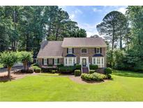 Charming two-story home with brick facade, lush landscaping, and a well-manicured lawn at 1324 Concord Sw Cir, Lilburn, GA 30047