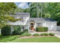 Charming two-story home with white siding, an attached garage, a manicured lawn and mature landscaping at 2716 Meadow Ridge Nw Dr, Duluth, GA 30096