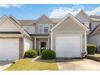 Charming townhome featuring neutral siding, a one-car garage, and lovely landscaping on a sunny day at 5351 Paramount View Way, Sugar Hill, GA 30518