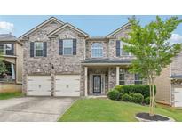 Charming brick home with a manicured lawn, two-car garage, and inviting front entrance at 931 Sublime Trl, Canton, GA 30114
