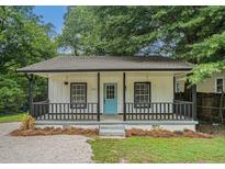 Charming home featuring a welcoming front porch with black railings and a bright blue front door at 1917 Connally Dr, Atlanta, GA 30344