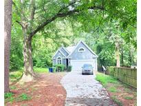 Charming home featuring a well-maintained front yard and a long driveway leading to an attached garage at 195 Burbank Nw Dr, Atlanta, GA 30314