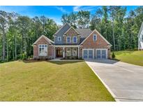 Beautiful two-story home featuring brick, stone accents, a well-manicured lawn and an attached two-car garage at 1114 Low Water Crossing Nw, Acworth, GA 30101