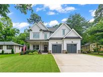 Charming two-story home with a landscaped lawn and a two-car garage on a beautiful sunny day at 1442 Pierce Se Ave, Smyrna, GA 30080