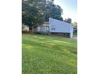 Charming home featuring a deck and well-maintained front yard with lots of grass and mature trees at 102 Bascomb Drive Dr, Woodstock, GA 30189
