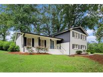 Charming two-story home featuring a manicured lawn, fresh white paint, and contrasting black trim at 2702 Galaxy Ct, Decatur, GA 30034