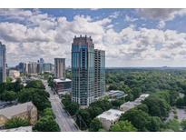 Stunning aerial view of a modern high-rise condo building amidst lush green surroundings and city skyline at 2795 Peachtree Ne Rd # 703, Atlanta, GA 30305