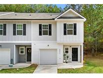Charming two-story townhome featuring a one-car garage, a covered entry, and stylish black shutters at 4992 Lower Elm St, Atlanta, GA 30349