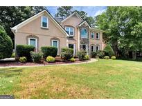Charming two-story home with a manicured lawn and mature landscaping creating great curb appeal at 4335 Burgomeister Pl, Snellville, GA 30039