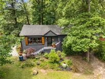 Charming single-story home with a dark gray exterior, landscaped front yard, and shutters surrounded by lush trees at 2468 Fallview Ter, Atlanta, GA 30344