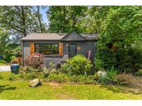 Charming home featuring a dark gray exterior, well-manicured landscaping, and eye-catching wooden window shutters at 2468 Fallview Ter, Atlanta, GA 30344