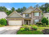 Charming two-story home featuring brick and stone accents, a well-manicured lawn, and a two-car garage at 58 Lilyfield Ln, Acworth, GA 30101