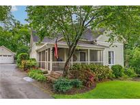 Charming home featuring a screened-in porch, lush landscaping, and a detached garage at 4520 Dallas St, Acworth, GA 30101
