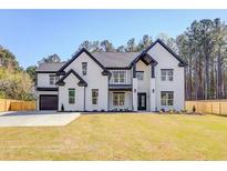 Stunning two-story home with black trim, a manicured lawn, and a spacious driveway at 0 Thompson Mill Rd, Buford, GA 30519