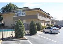 Well-maintained building exterior featuring a pool, parking area, and manicured landscaping at 346 Carpenter Drive Northeast Dr # 32, Sandy Springs, GA 30328