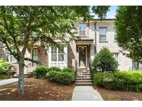 Charming brick townhouse with a well-manicured lawn and inviting entryway steps at 3657 Atherton Park Ct, Suwanee, GA 30024