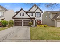 Charming two-story home features a well-manicured lawn and a two-car garage at 610 Syemore Pass, Canton, GA 30115