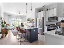 Bright kitchen with stainless appliances, a center island with bar stools, and view into the living space at 625 Piedmont Ne Ave # 3029, Atlanta, GA 30308