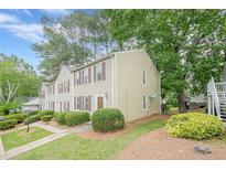 Traditional townhome featuring a well-manicured front yard, neutral siding, and complementing dark brown shutters at 3403 Spring Harbour Drive Dr, Doraville, GA 30340