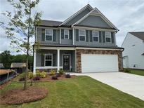 Charming two-story home features a manicured lawn, stone accents and a two car garage at 777 Oakmont Trce, Canton, GA 30114