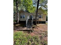 Inviting home featuring an exterior deck and stairs surrounded by mature trees at 4050 Willow Ridge Rd, Douglasville, GA 30135