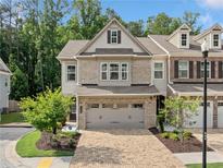 Beautiful brick-and-siding townhome with a well-manicured lawn and an attached two-car garage at 490 Duval Dr, Alpharetta, GA 30009
